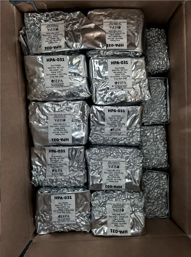 Foil sachets of hop pellets in an opened carton, each carrying its own lot label