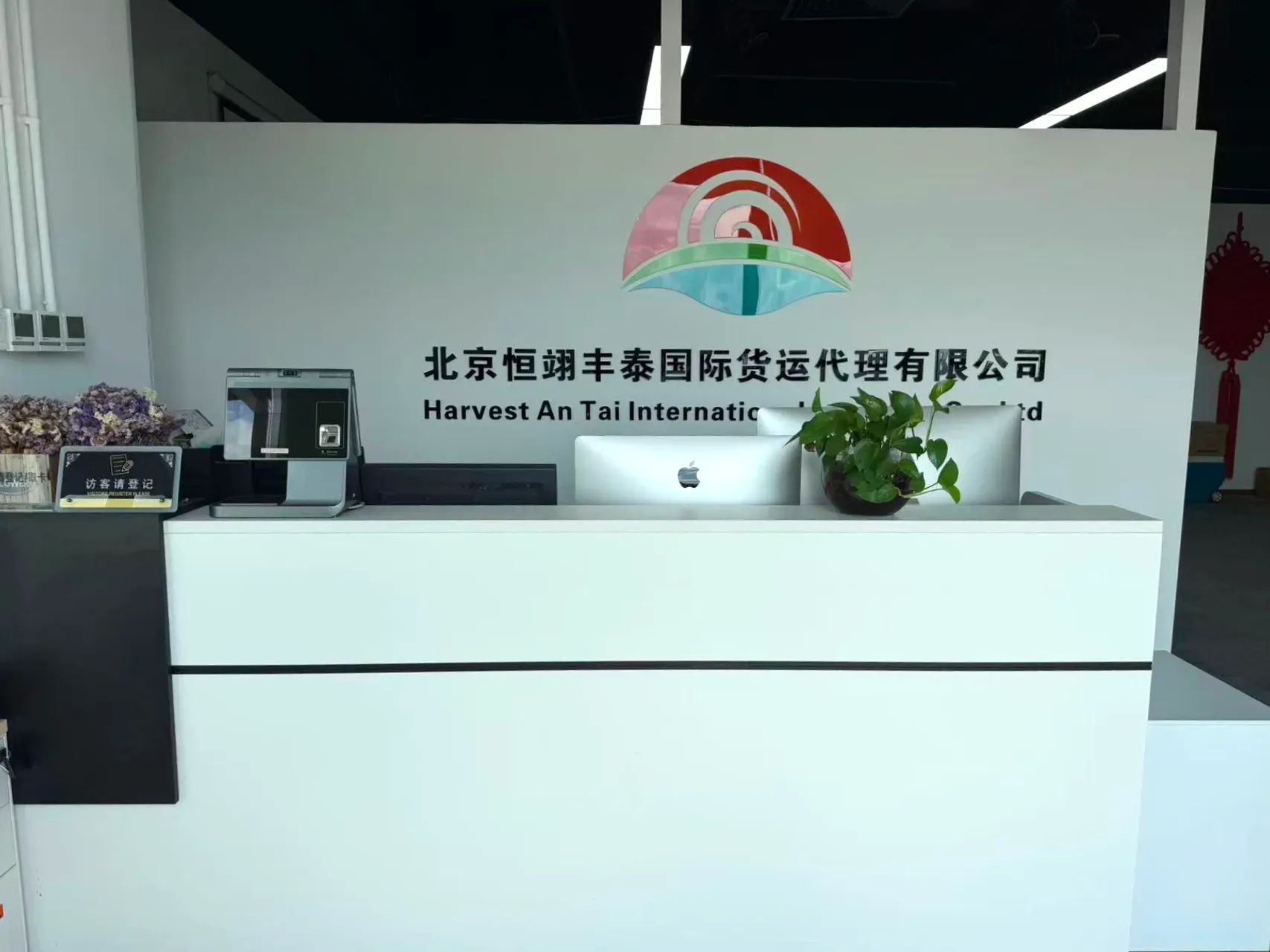 The reception desk at Harvest An Tai's Beijing office, with the company name and logo on the wall behind it