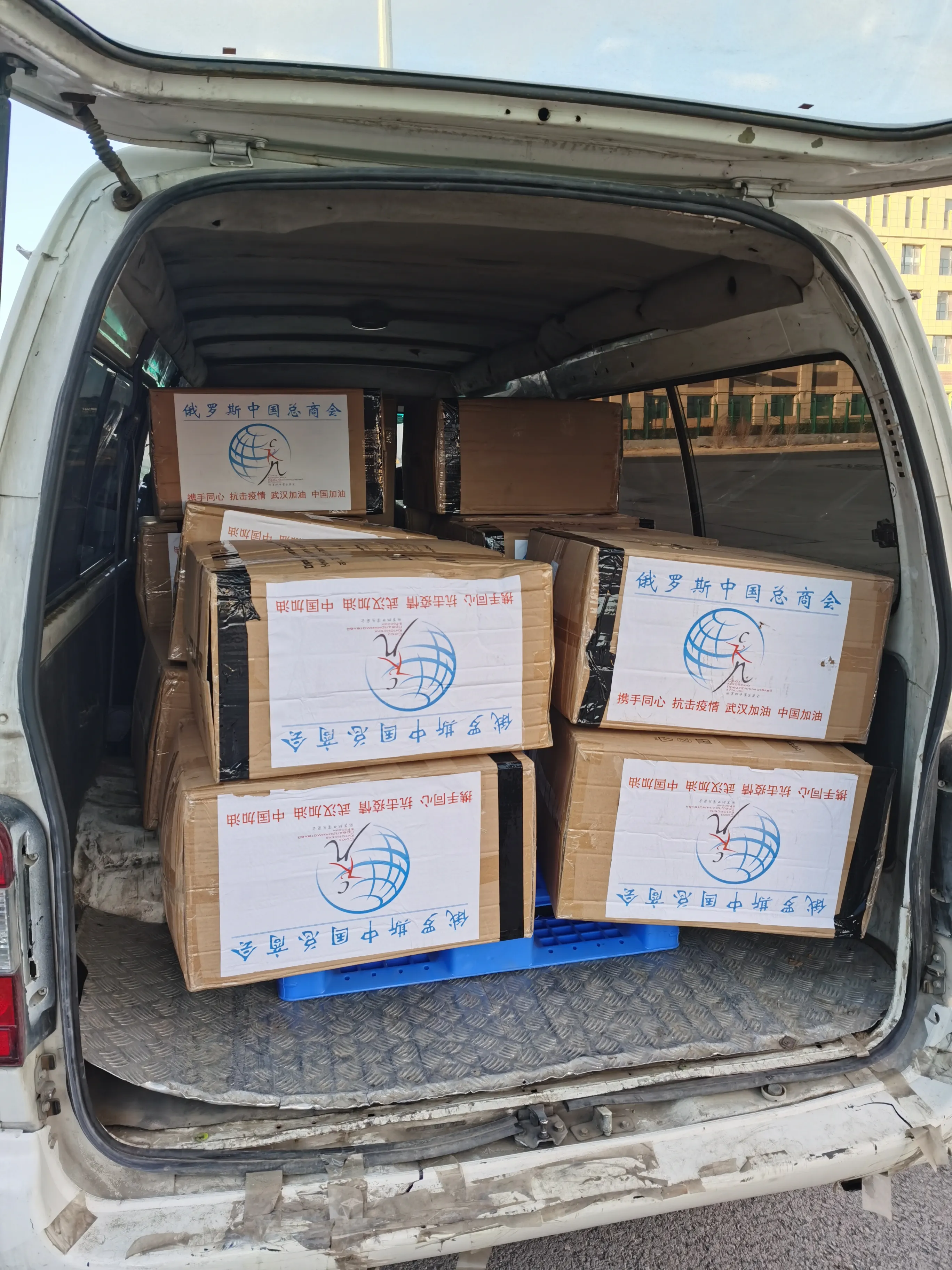 Cartons donated by the Chinese chamber of commerce in Russia loaded into a van for onward delivery