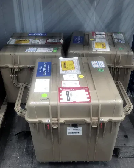 Three insulated hard transit cases stacked and labelled for refrigerated carriage