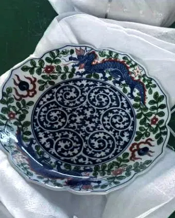 A blue and white porcelain dish with a dragon pattern, laid on white cloth