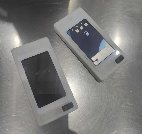 Two compact electronic units laid out on a stainless-steel inspection surface